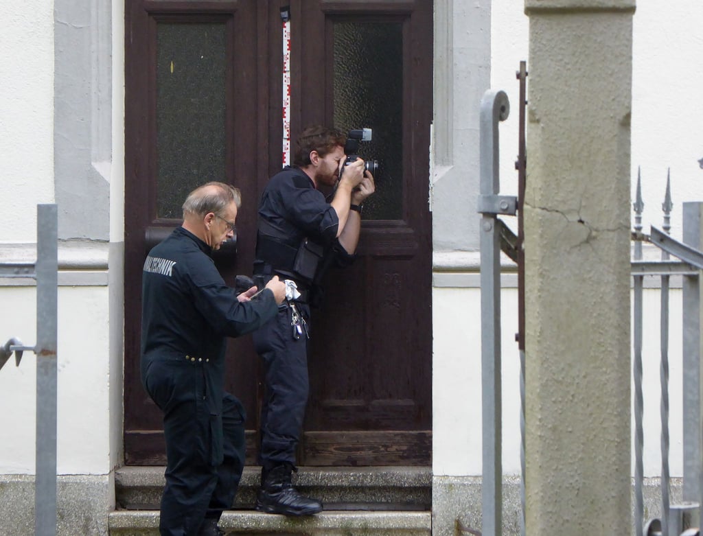 Polizeibeamte vor einem Wohnhaus, in dem in der Nacht eine Mutter und ihr Kind getötet worden waren.