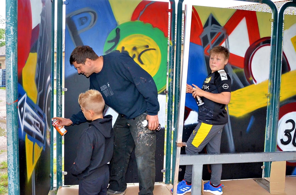 Diplomdesigner Michael Braune aus Schernebeck zeigt Jamie und Vince, wie richtig gesprayt wird. Entstanden ist ein Graffiti aus Verkehrszeichen.