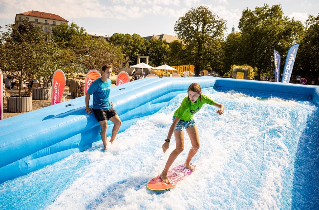 Eine Surferin surft in einer temporär aufgebauten Surf-Anlage auf dem Opernplatz in der Innenstadt.