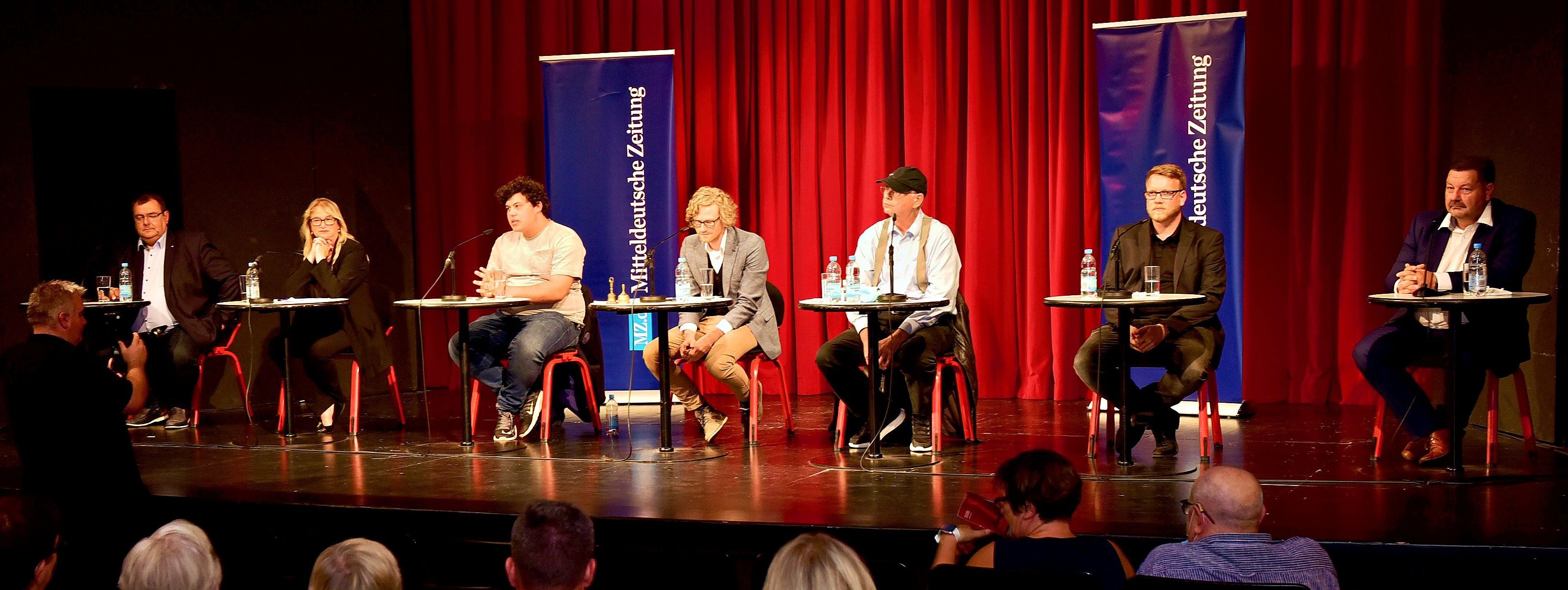 Auf der Bühne des  Theaters Eisleben postierten sich die sechs Direktkandidaten beim MZ-Wahlforum um Moderator und Chefreporter Joel Stubert (Mitte).
