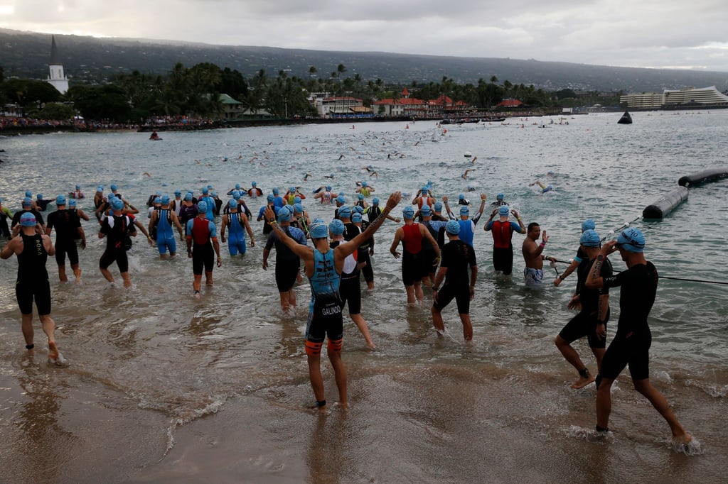 2019: Athleten stehen im Wasser der Kailia Bay für den Schwimmteil des Triathlons.