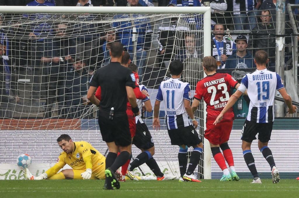 Bielefelds Torwart Stefan Ortega (l) kassiert den Gegentreffer zum 0:1 durch Frankfurts Jens Petter Hauge (2.v.r).