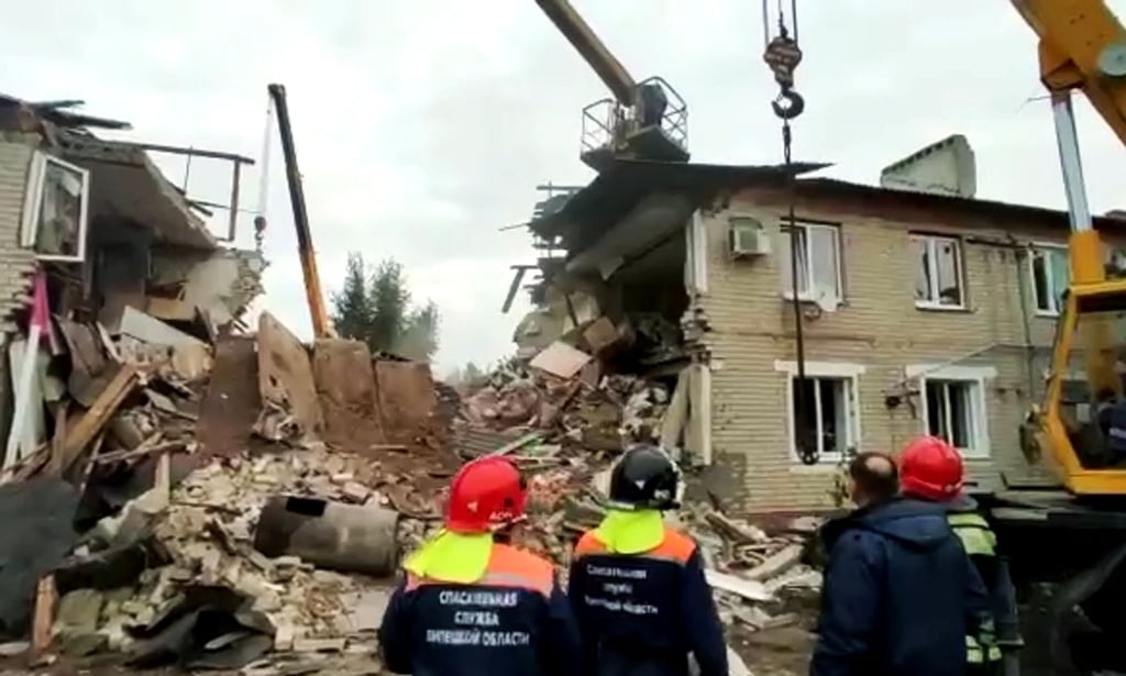 Das Standbild aus einem Video des russischen Katastrophenschutzministeriums zeigt Rettungskräfte vor einem nach einer Gasexplosion zerstörten zweistöckigen Wohnhaus.