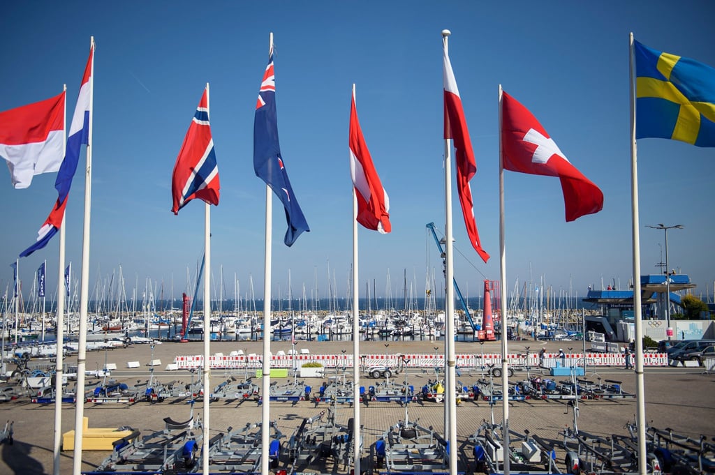 Fahnen verschiedener Länder wehen über dem Sportboothafen während der Kieler Woche.