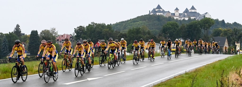 Radfahrer sind beim "European Peace Ride" vor der Augustusburg unterwegs.