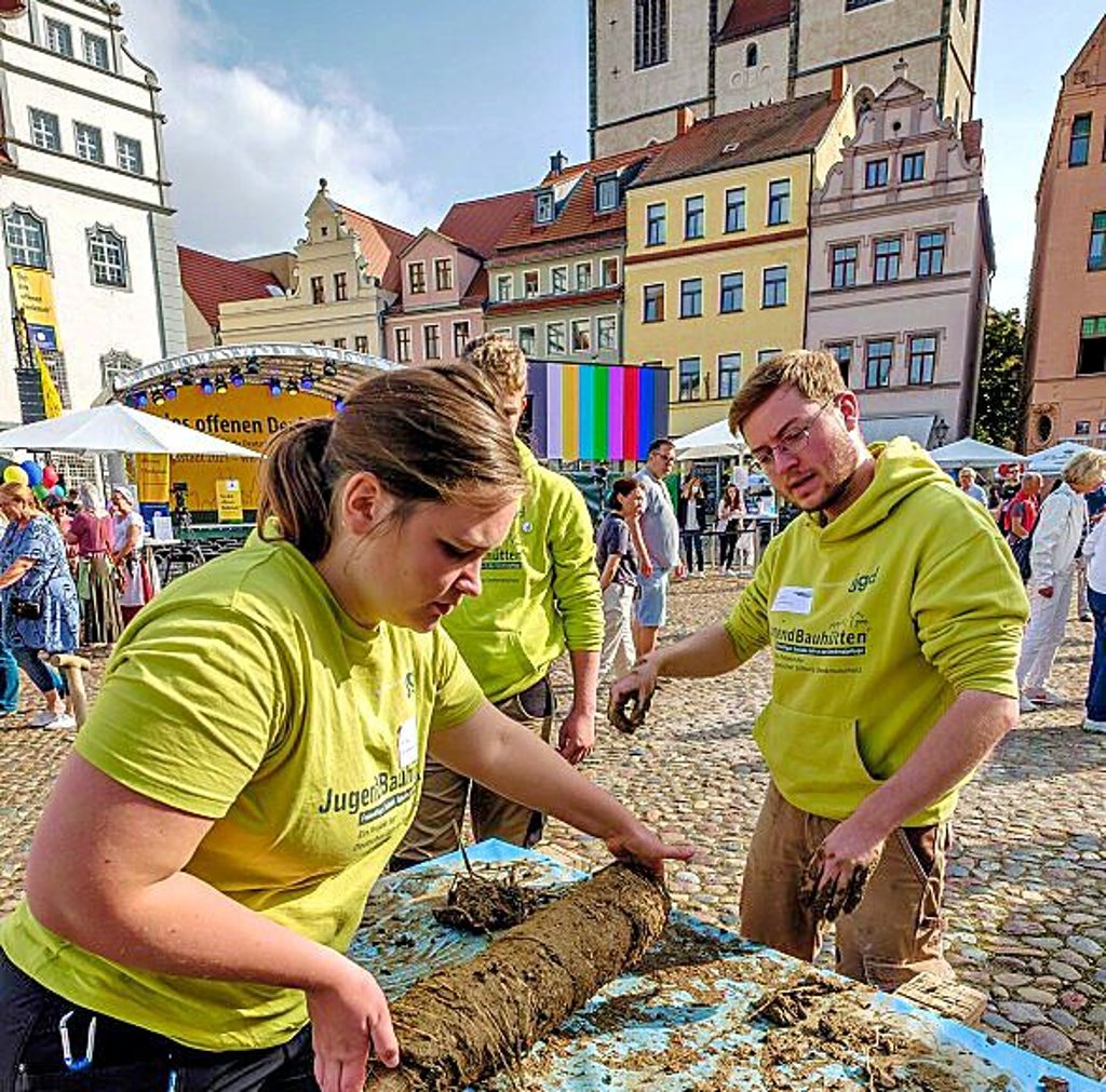 Mitarbeiter der Jugend-Bauhütten machen Lehmwickelstaken.