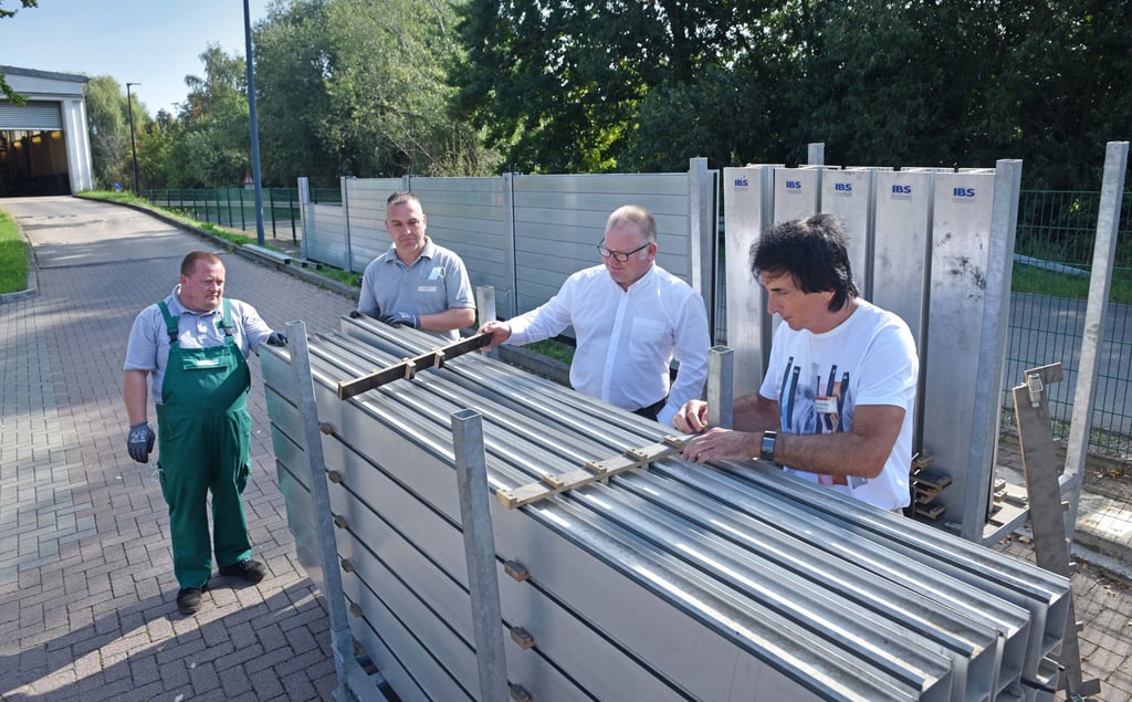 Facility Manager Joachim Wormuth, Geschäftsführer René Rottleb und die Mitarbeiter Manuel Thielicke und Alexander Karaew (v. r.) vom Gesundheitszentrum erklären und präsentieren, wie die Hochwasserschutzwand installiert wird.
