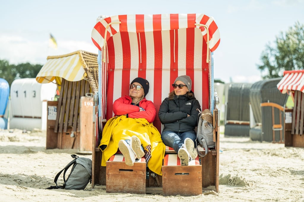 Die Urlauberinnen Claudia (l) und Julia aus Baden-Württemberg sitzen in einem Strandkorb am Strand von Dangast.