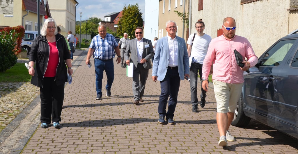 Dorfrundgang in Kleinmühlingen. Angeführt von Ortsbürgermeister Tim Andy Sroka (vorne rechts) und Bürgermeister Bernd Nimmich (vorne Mitte) nimmt eine Juey das Dorf in Augenschein.