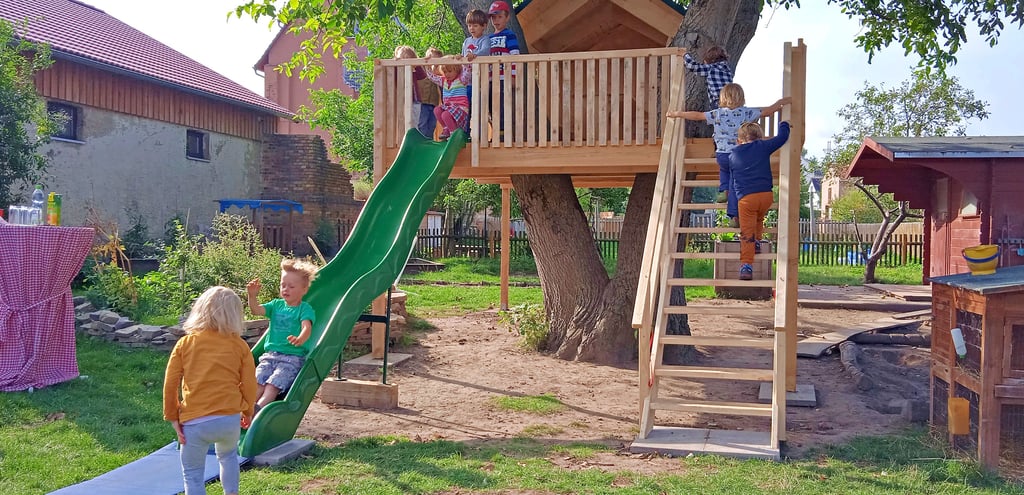 Begeistert nehmen die Kinder der Naturgruppe ihre Baumhausrutsche in Besitz.