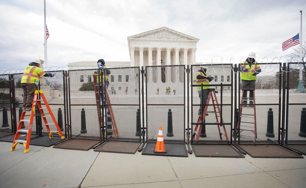 Arbeiter stehen am Sicherheitszaun vor dem US-Kapitol (Archivfoto vom 22. Januar).