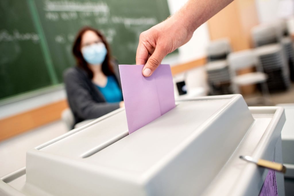 Ein Wähler wirft einen Zettel in die Wahlurne.