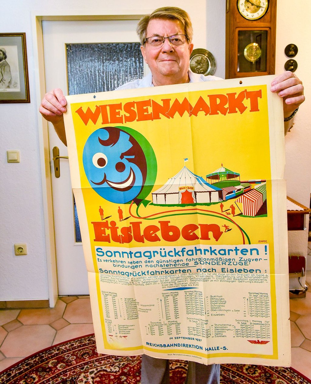 Peter Lindner mit einem Plakat von 1937 zu Wiesen-Sonderfahrten.