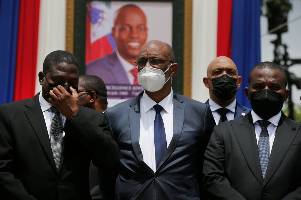 Ariel Henry (M), designierter Premierminister von Haiti, und Interims-Regierungschef Claude Joseph (r) stehen vor einem Porträt des ermordeten haitianischen Präsidenten Jovenel Moise.