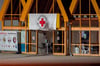 Eine Rot-Kreuz-Fahne hängt über dem Eingang zum Impfzentrum:  Im sächsischen Vogtlandkreis hat es einen Brandanschlag auf ein Impfzentrum gegeben.