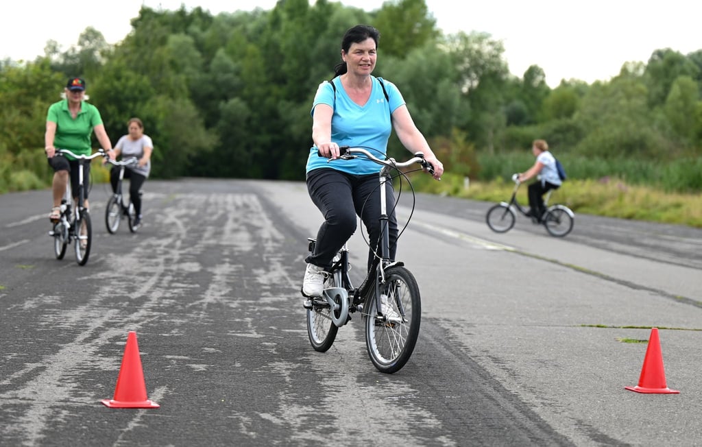 Monika Kraus (vorn) aus Marburg nimmt an einem Radfahrkurs auf dem Alten Flugplatz im Stadtteil Bonames teil. Die Kurse wenden sich gleichermaßen an Anfänger, Wiedereinsteiger und an unsichere Radfahrerinnen und Radfahrer.