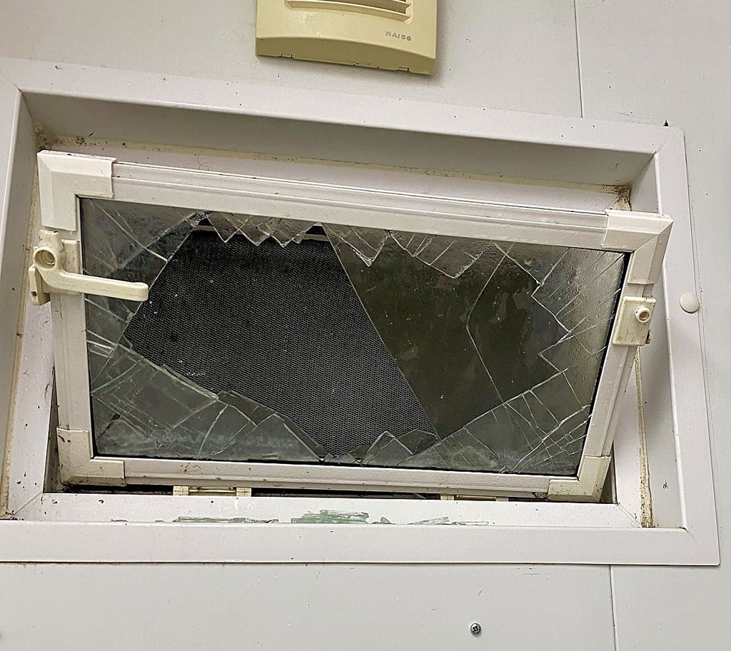 Ein zerstörtes Fenster in dem Sanitärgebäude
