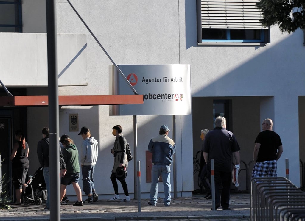Menschen warten vor dem Jobcenter in Dessau