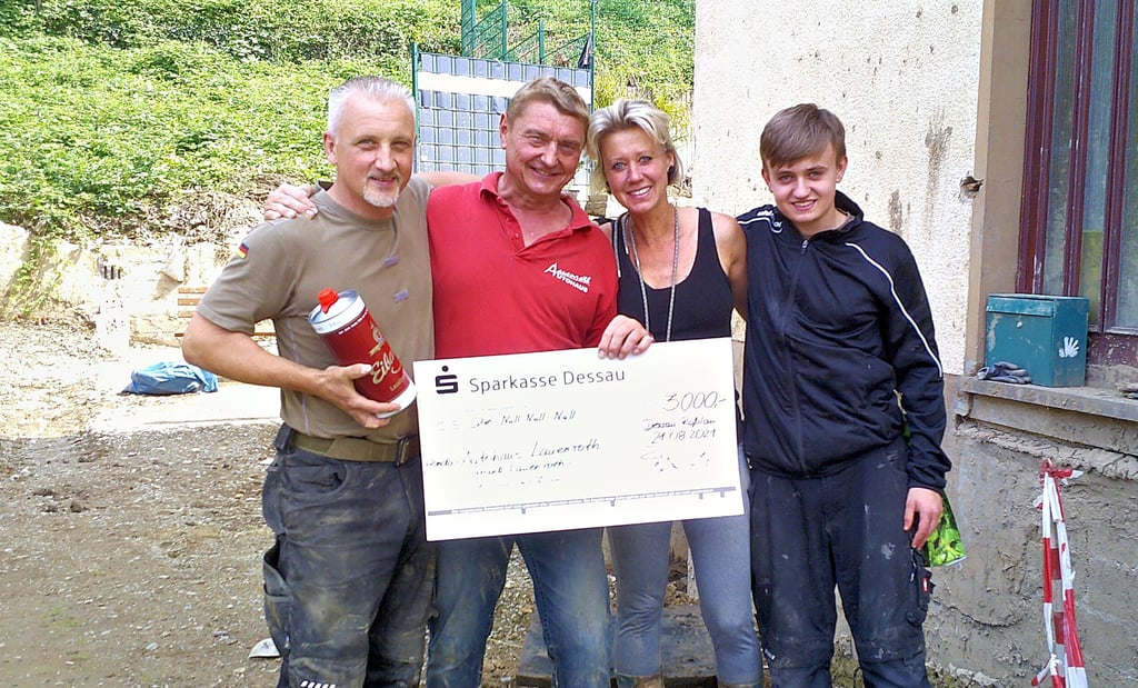 Frank Lauenroth aus Dessau (rotes T-Shirt) hilft einer Familie aus Altenburg an der Ahr mit Spenden und Muskelkraft.