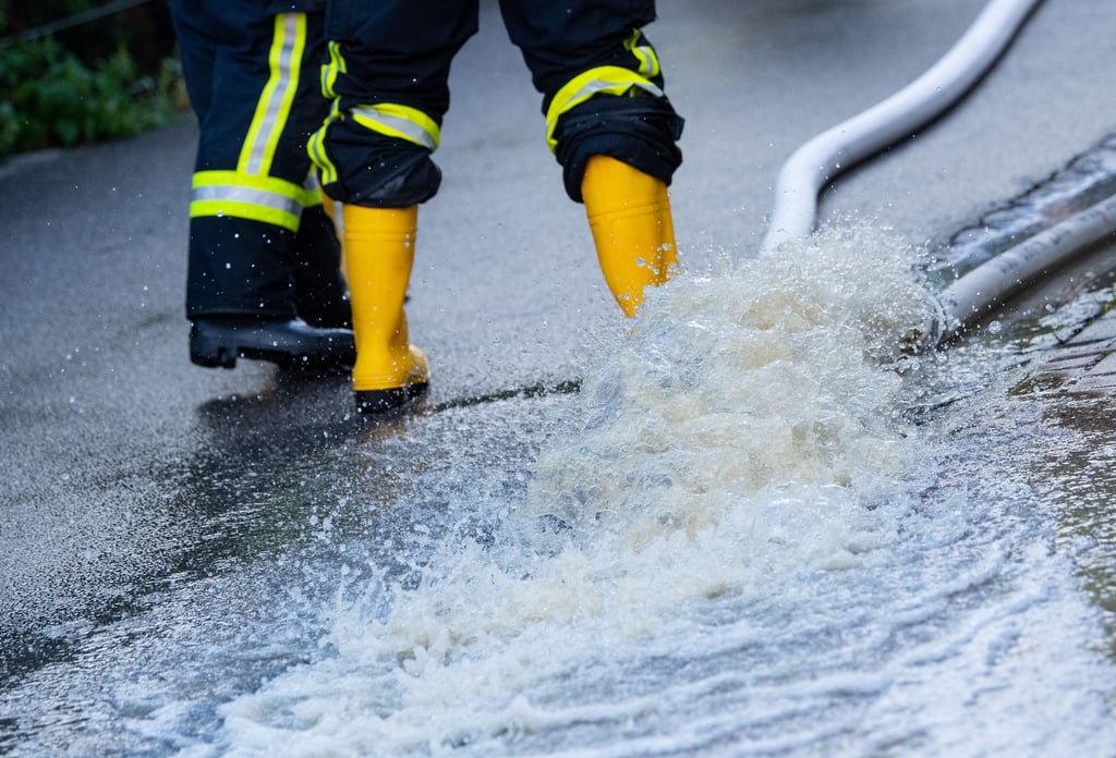 Illustration: Nach starken Regenfällen wird Wasser aus einem vollgelaufenen Keller abgepumt.