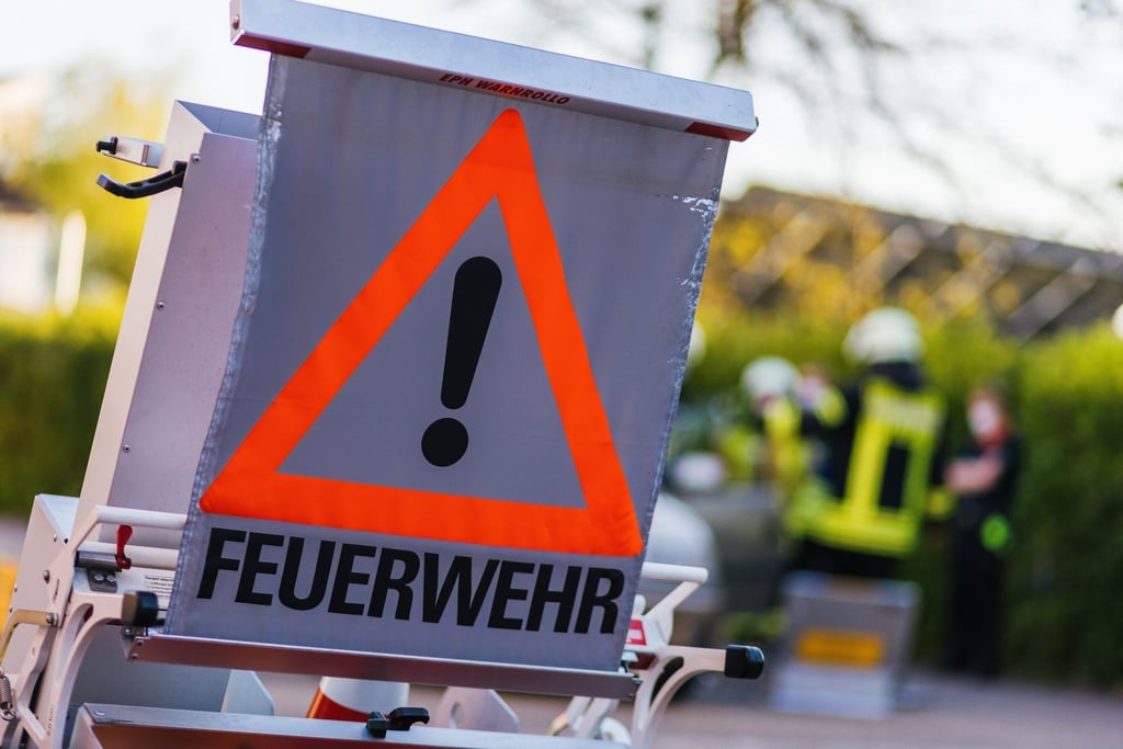 Ein Schild mit der Aufschrift „Feuerwehr“ steht auf dem Hof eines Feuerwehrgerätehauses.