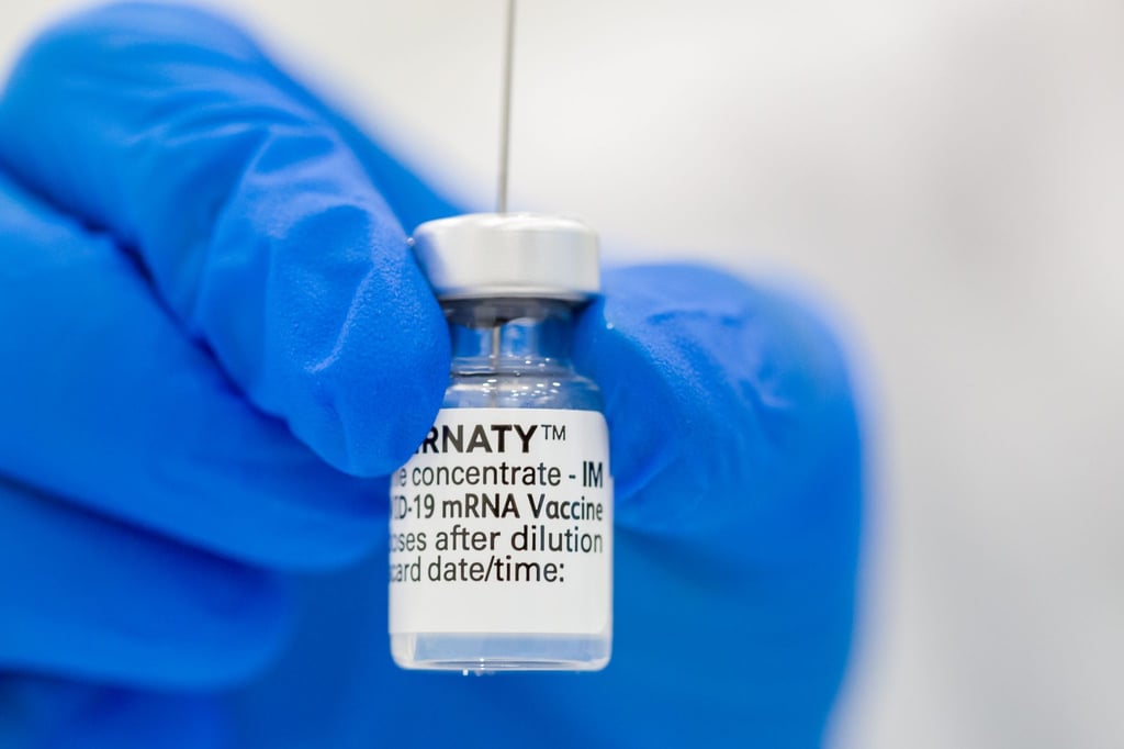 Eine medizinische Fachkraft ein Fläschen mit dem Pfizer-BioNTech-COVID-19-Impfstoff in der Hand.