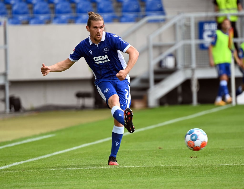 Der Karlsruher Sebastian Jung schießt dem Ball.