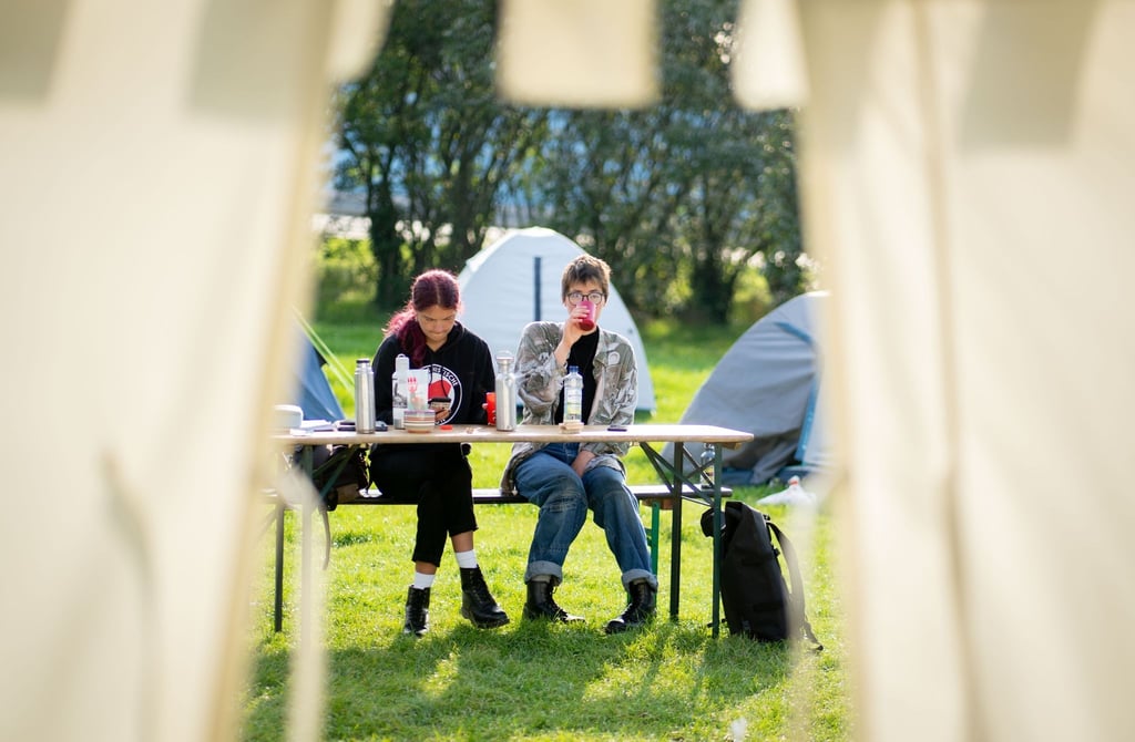 Lina Eichler (r) und Mephisto sitzen vor den Zelten ihres Protestcamps im Regierungsviertel.
