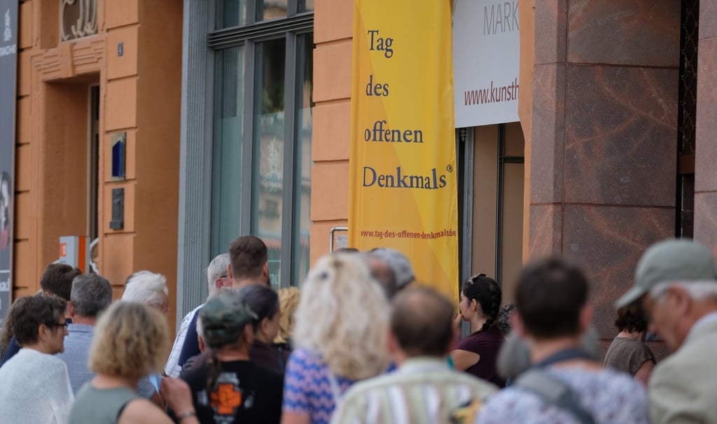 Besucher stehen vor einem historischen Gebäude in Wittenberg Schlange.