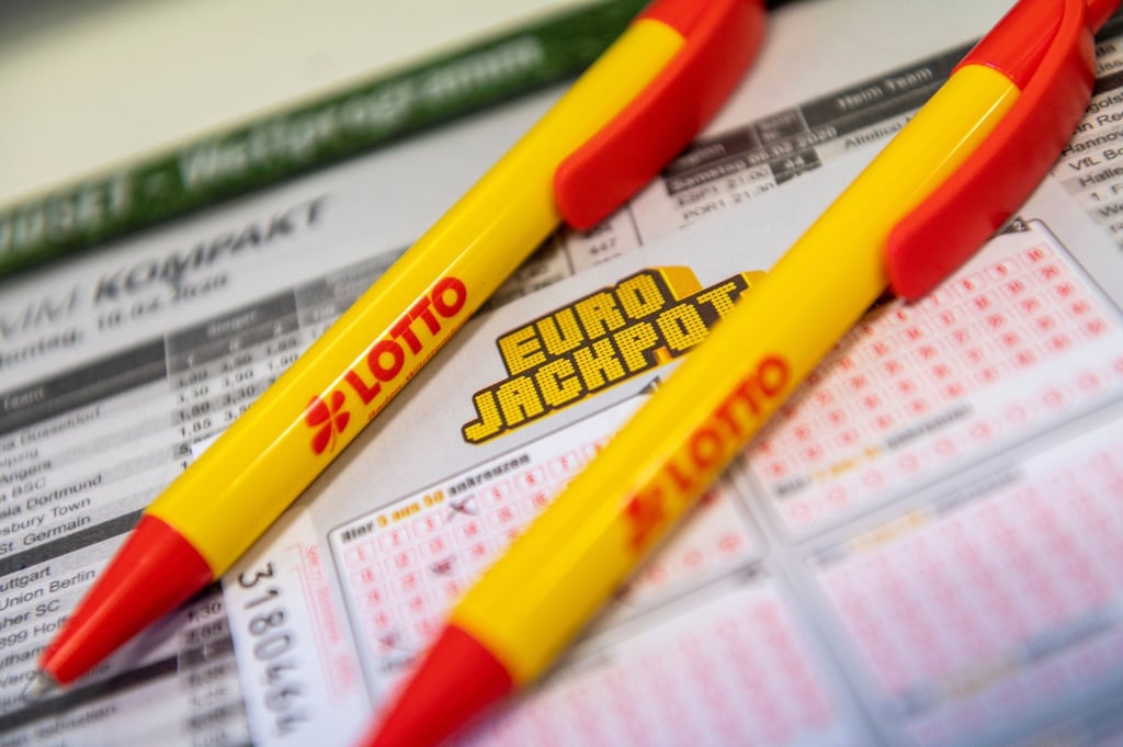 Ein Los für den Eurojackpot und ein Kugelschreiber liegen in einer Lotto-Annahmestelle.