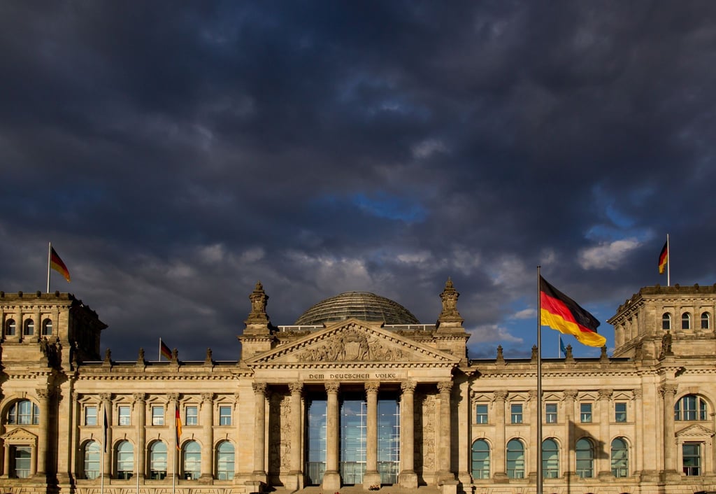 Dunkle Wolken ziehen über das Reichstagsgebäude in Berlin.