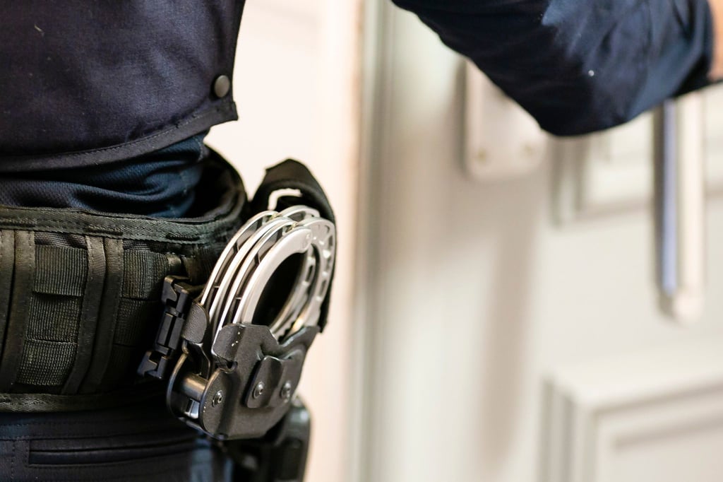 Handschellen sind an einem Gürtel eines Justizvollzugsbeamten befestigt.