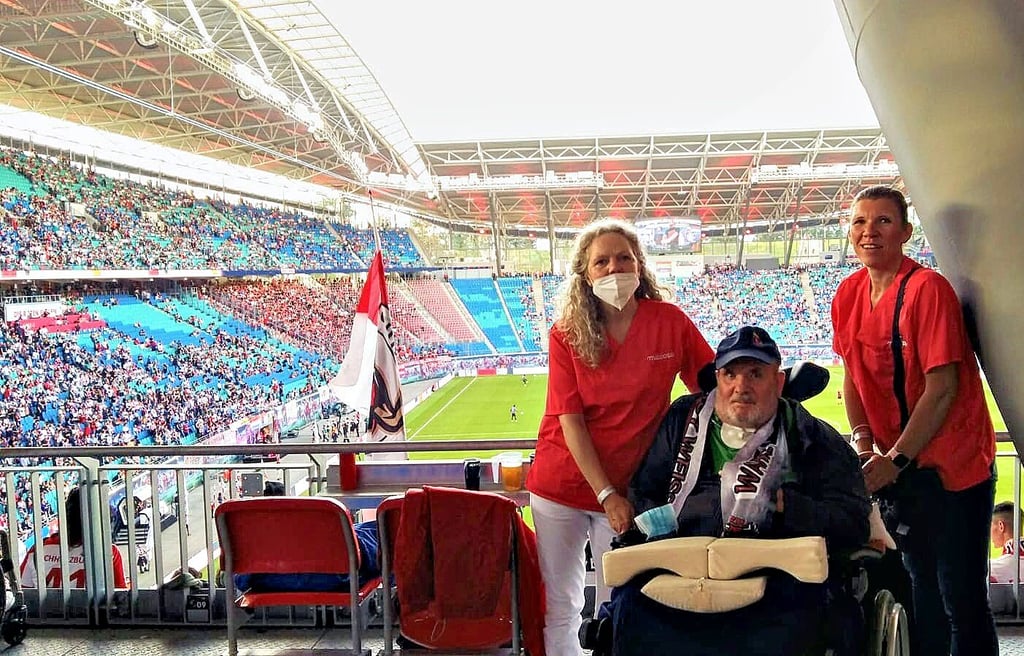 Norbert Schulz mit seinen Pflegerinnen Maren und Rafaela im Fußballstadion in Leipzig.
