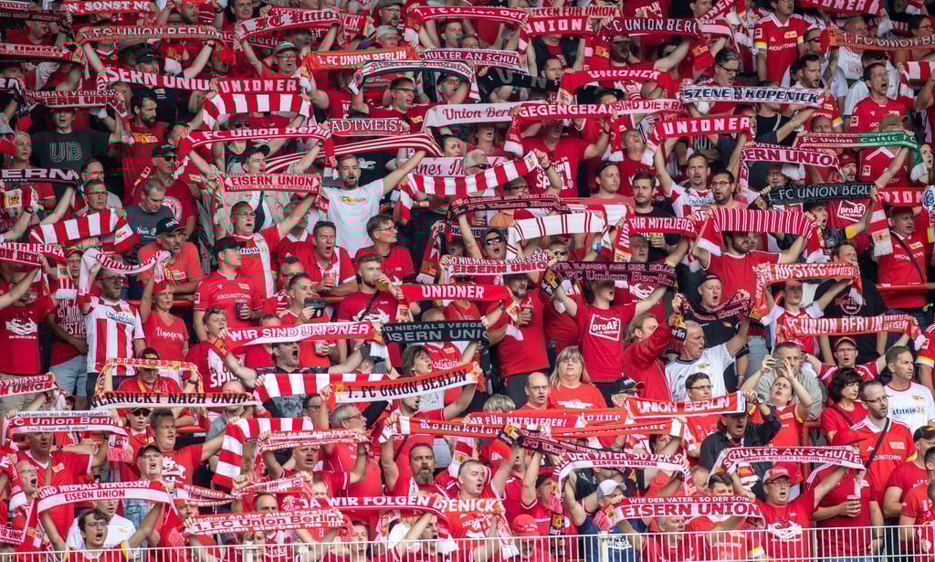 Fans von Union Berlin feuern ihr Team mit Schals an.