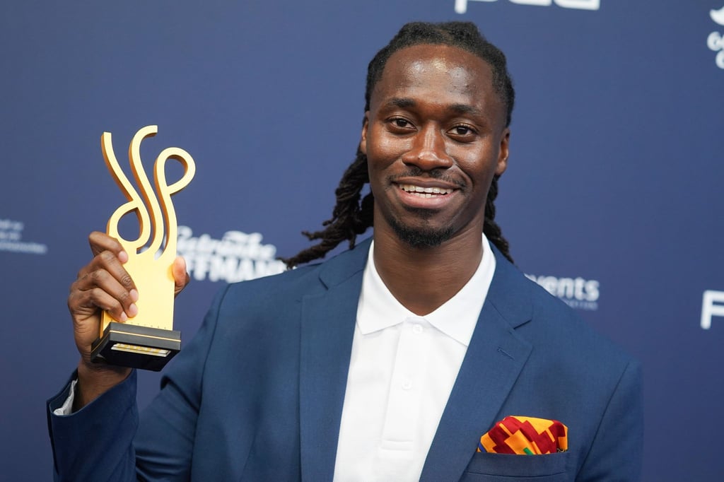 Der Schauspieler Eugene Boateng zeigt seinen Preis.