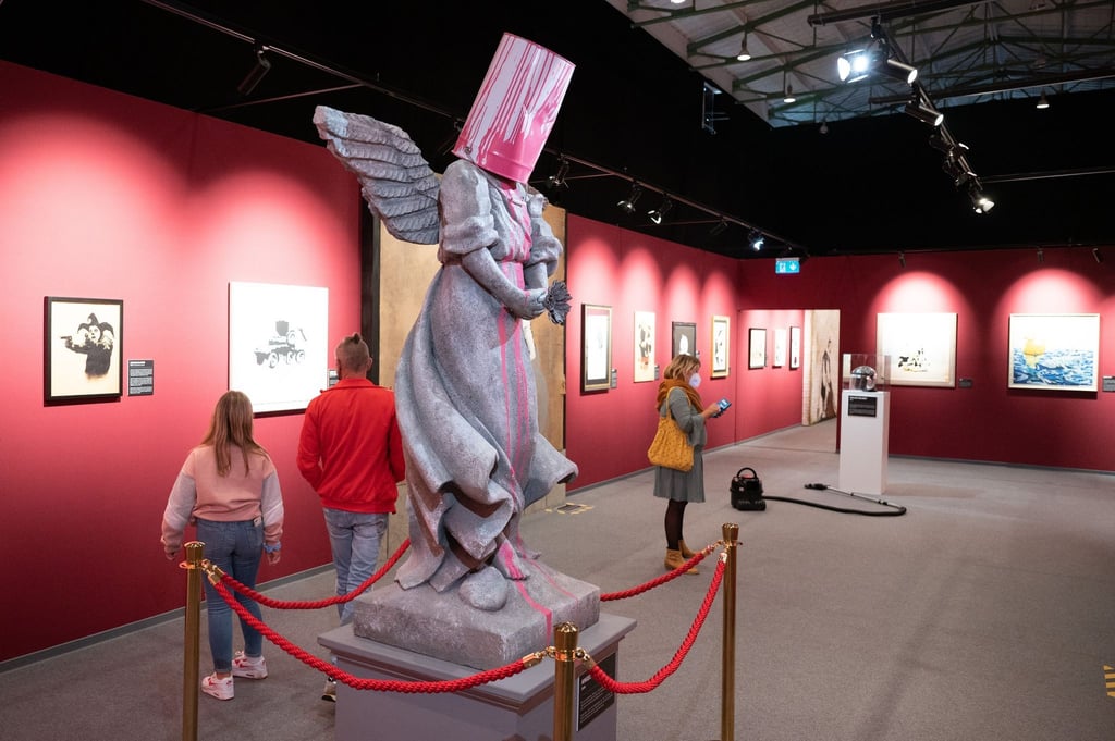 Besucher stehen hinter der Statue „Angel Bust“.