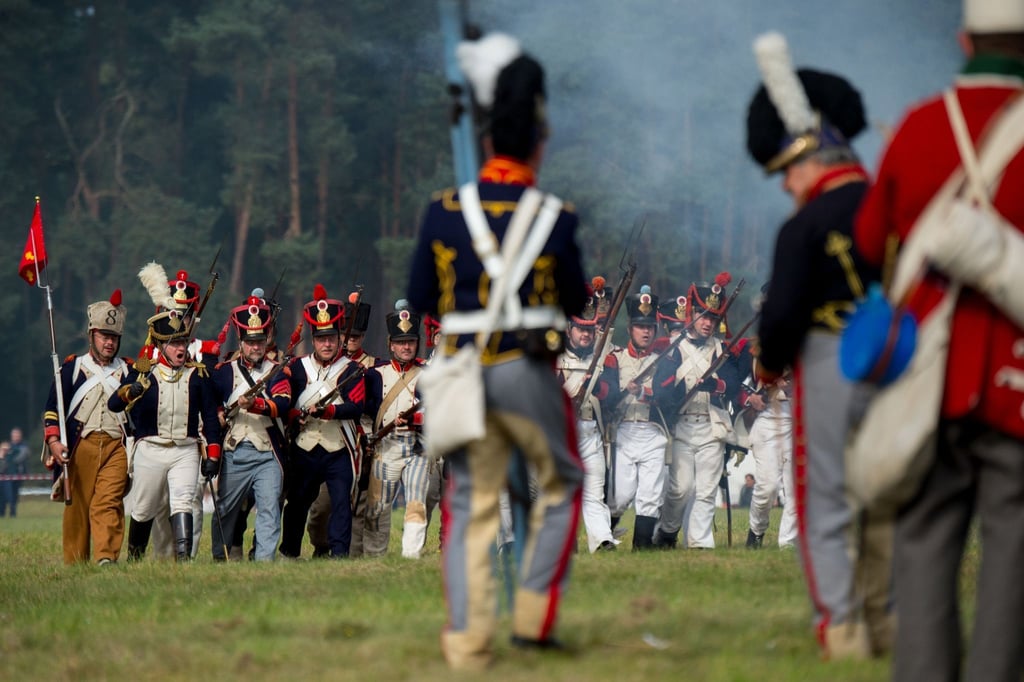 Als Soldaten verkleidete Darsteller „kämpfen“ mit ihren Waffen auf dem Schlachtfeld.
