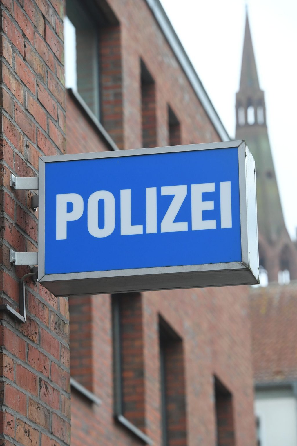 Ein Schild mit dem Schriftzug "Polizei" hängt an einer Polizeiwache.