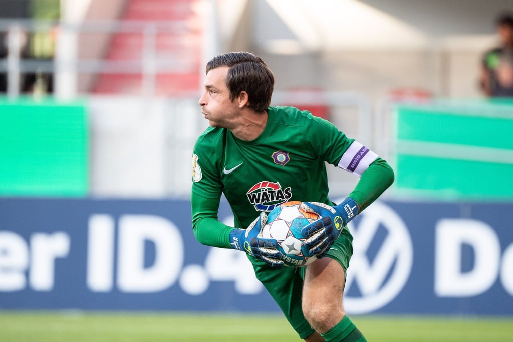 Torwart Martin Männel von Erzgebirge Aue hält den Ball.