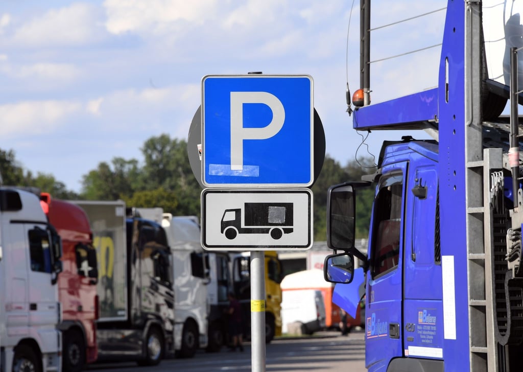 Lastwagen stehen an der Autobahn auf einem Rastplatz auf Lkw Parkplätzen.