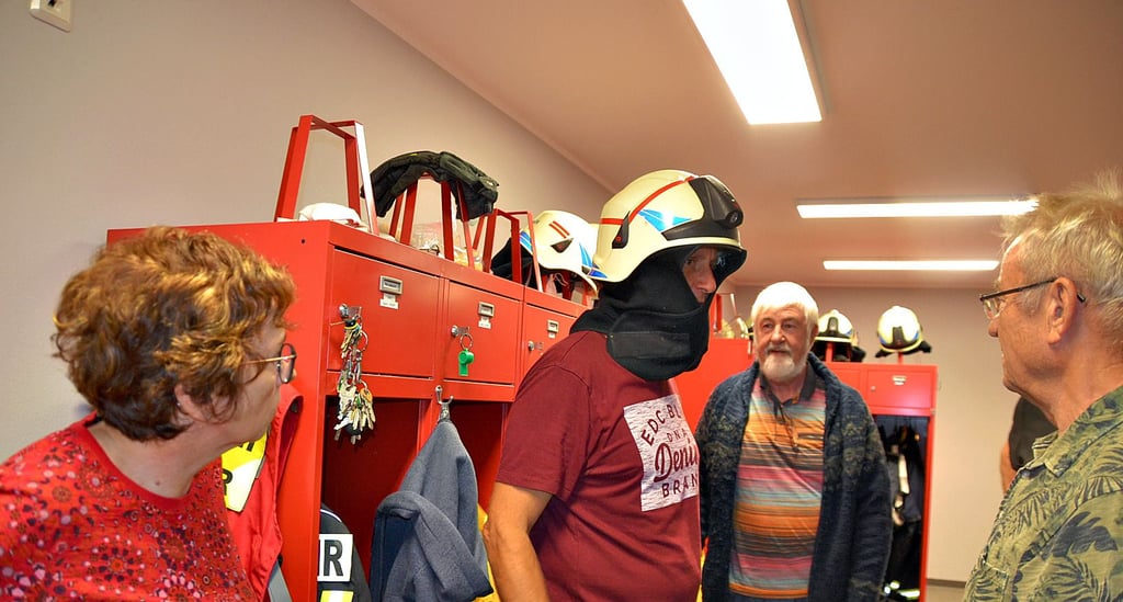 Wehrleiter Mathias Jaensch erklärt den Gästen der SPD im Feuerwehrgerätehaus, welche Möglichkeiten und Hilfsmittel es gibt, um sich vor der Hitze zu schitzen.