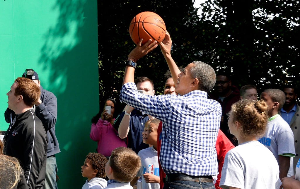 Barack Obama wirft beim White House Easter Egg Roll 2015 einen BasketBall auf den Korb.