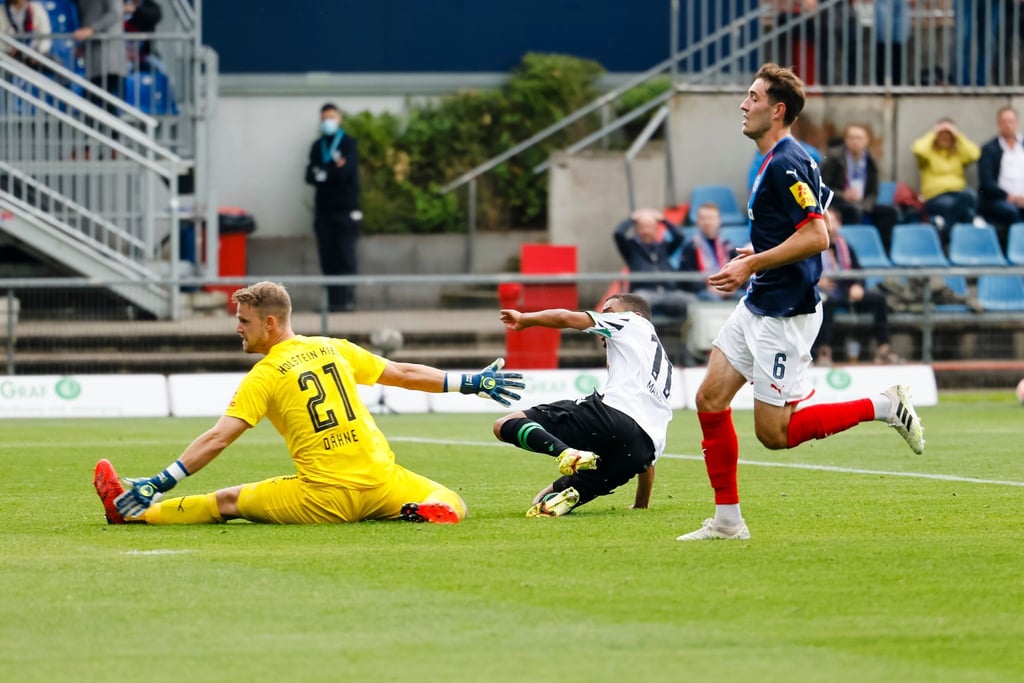 Hannovers Linton Maina (M) trifft gegen Kiels Torwart Thomas Dähne (l) und Marcel Benger zum 3:0.