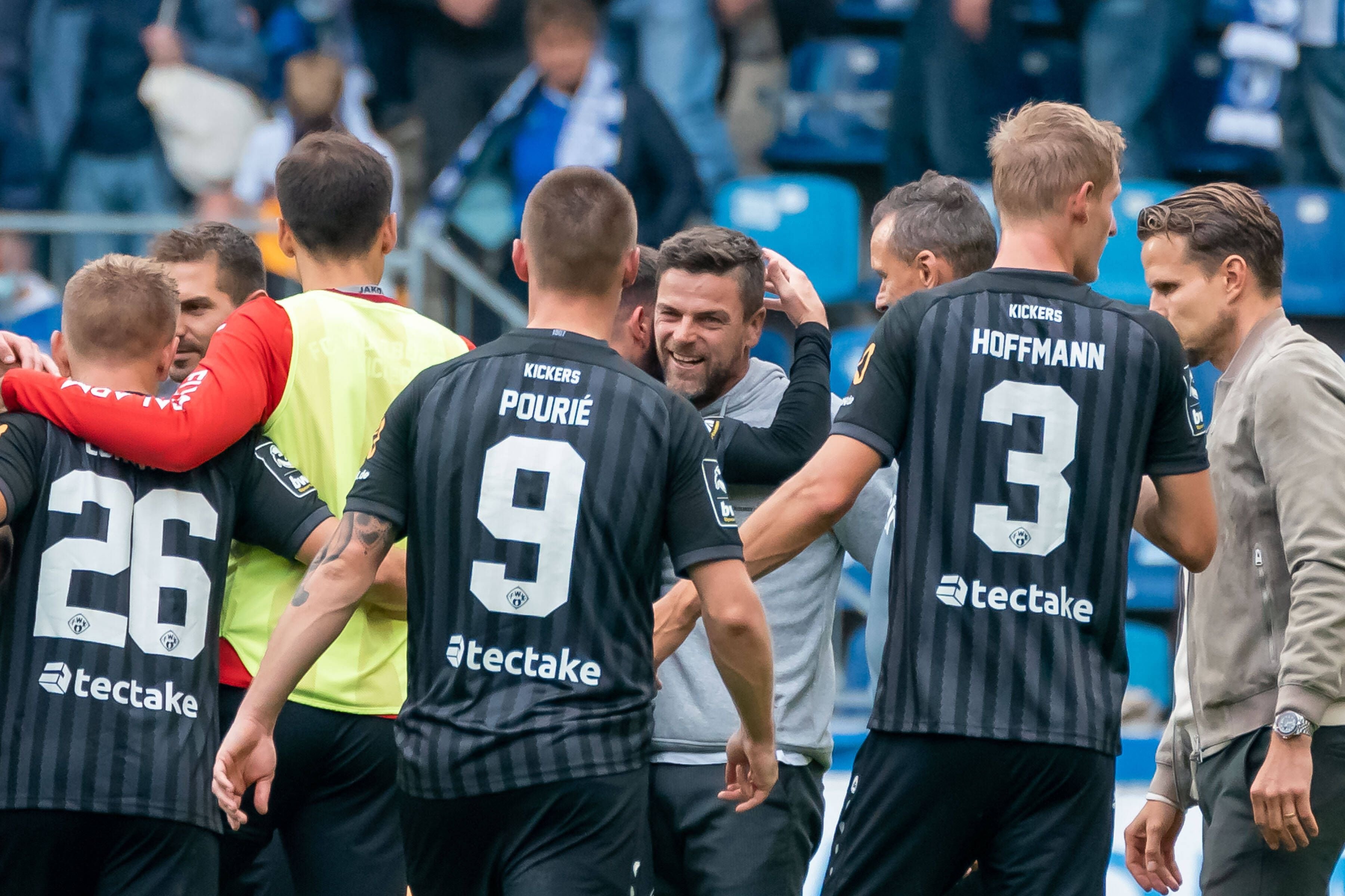 Torsten Ziegner feiert den Auswärtssieg seiner Würzburger Kickers in Magdeburg mit seinen Spielern.