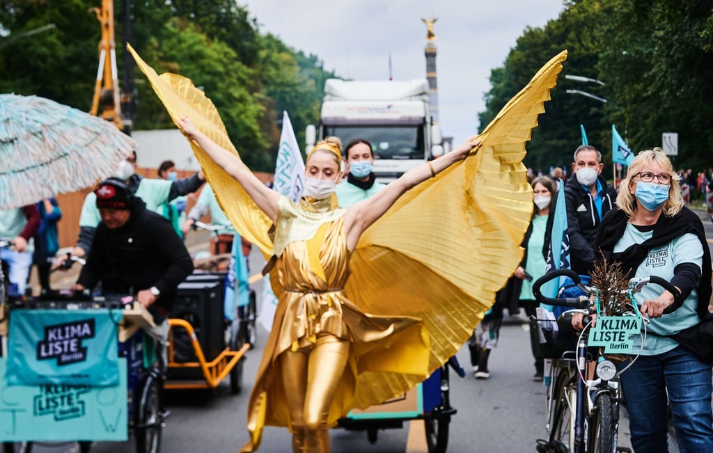 Ein tanzender Engel und die Partei Klimaliste führen den Umzug auf der Straße des 17. Juni an.