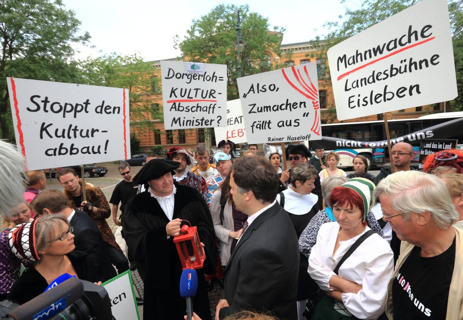 Ulrich Fischer, Intendant der Landesbühne Sachsen-Anhalt Lutherstadt Eisleben bietet vor der Staatskanzlei in Magdeburg dem Kultusminister des Landes Sachsen-Anhalt, Stephan Dorgerloh (SPD) symbolische eine rote Laterne an.