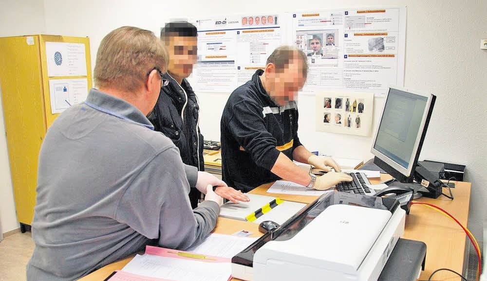 Im sogenannten Raum für erkennungsdienstliche Maßnahmen nehmen Beamte Fingerabdrücke von einem Verdächtigen.