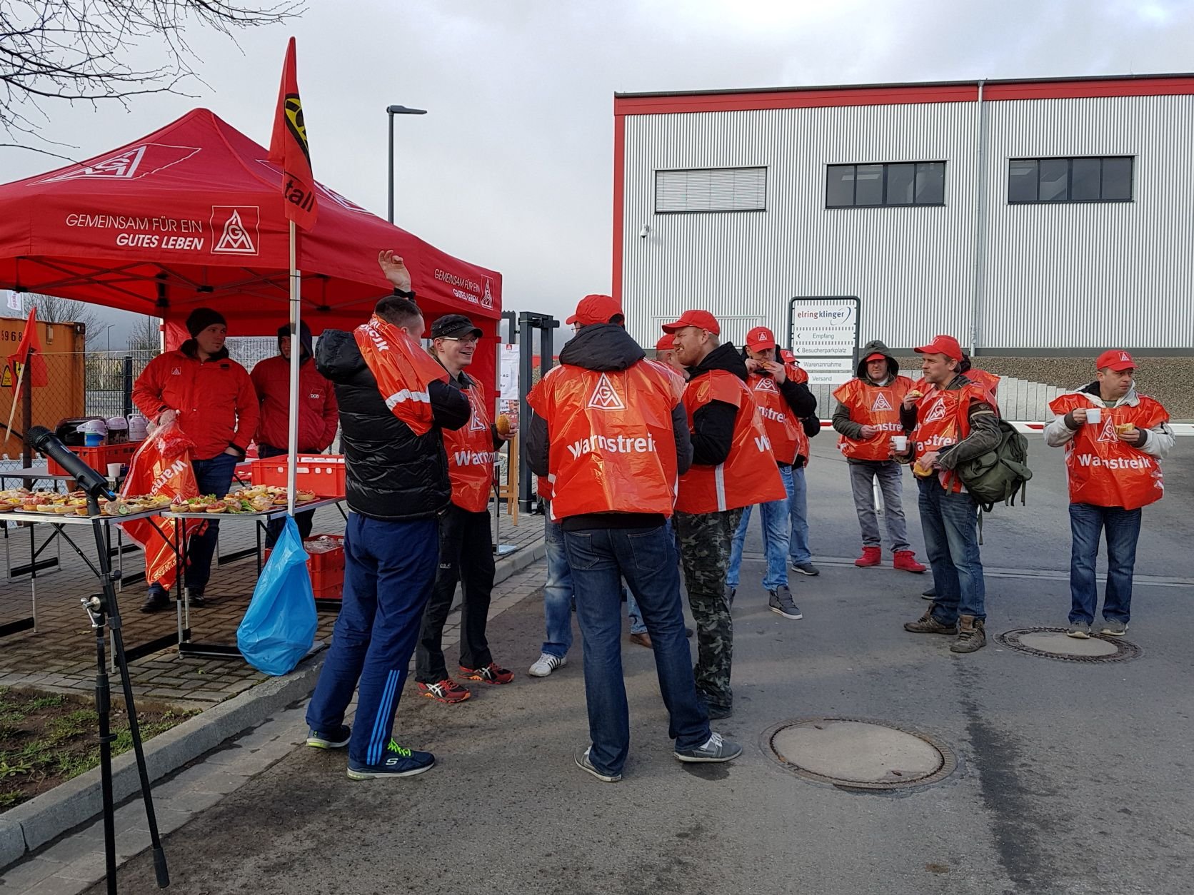 Mitarbeiter des Automobilzulieferers ElringKlinger in Thale stehen während des Warnstreiks am Betriebsgelände.