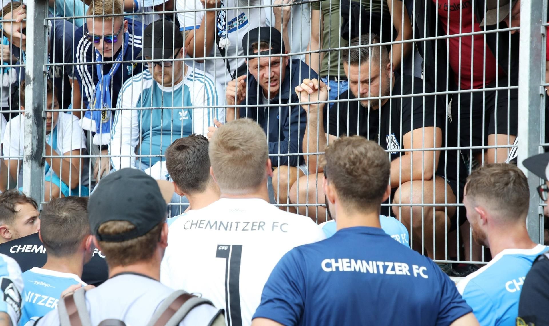 Daniel Frahn sitzt in Halle im Block neben führenden Köpfend er rechten Szene und spricht zu seinen CFC-Teamkollegen.