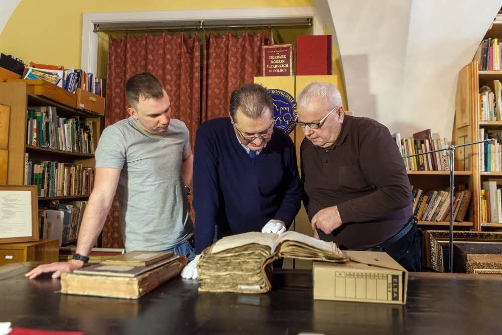 Dr. Jan Kruczek (r.) vom Museum Pszczyna ermöglicht Michael Schuster und Daniel Spielau (l.) einen Einblick in das Bestallungs- und Kassenbuch aus der Zeit Friedrich Erdmanns von Anhalt-Köthen ab 1765.